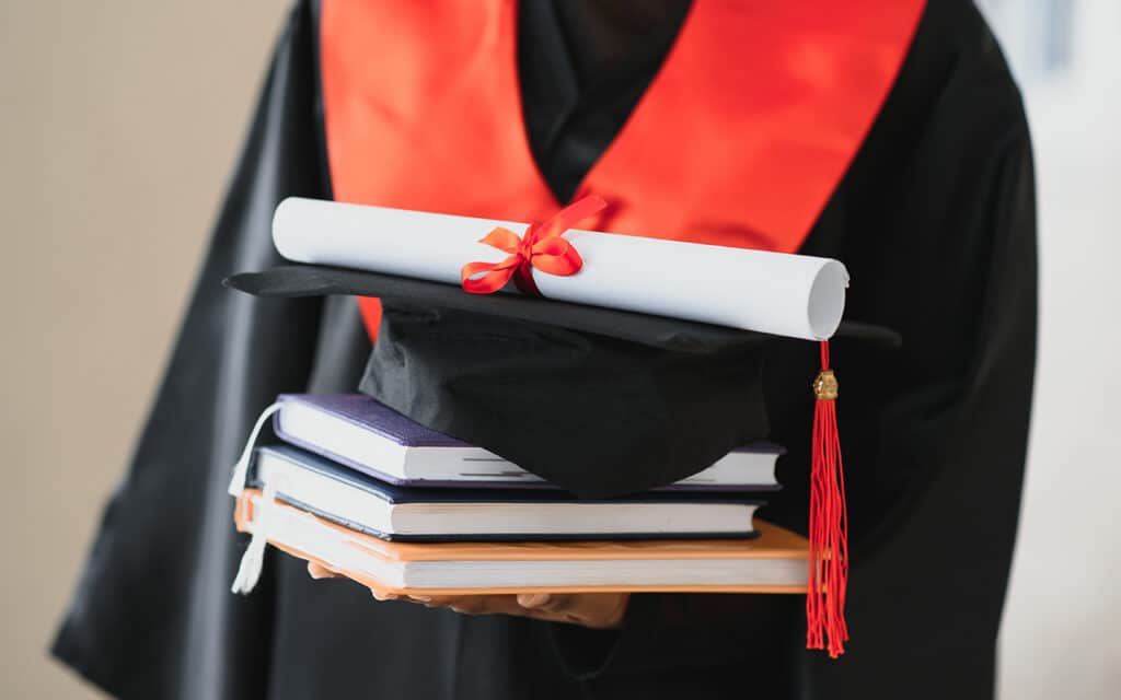 Estudiante graduado sosteniendo su TFG, TFM o tesis impresa en Madrid